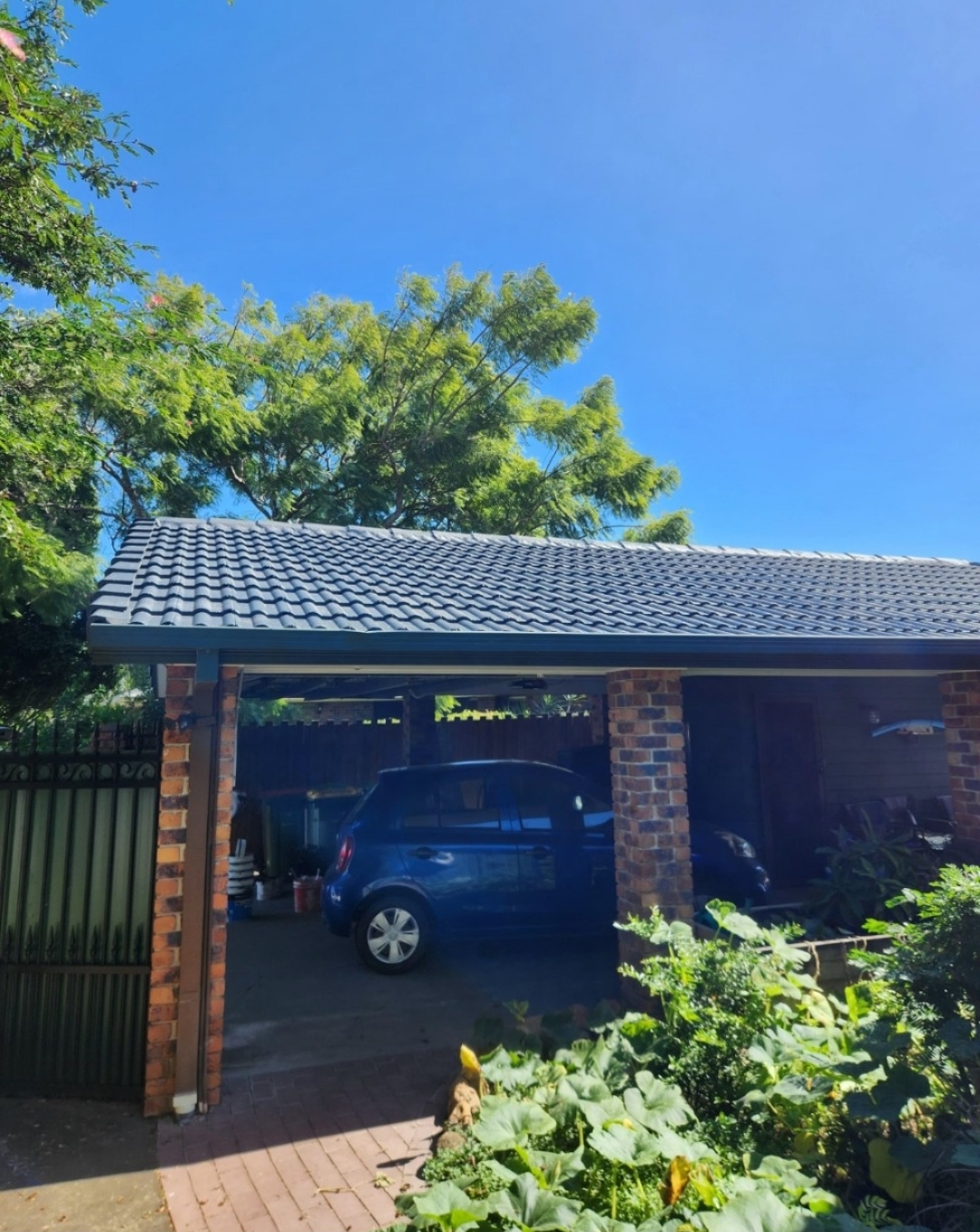 Carport and charcoal roof after painting, under blue sky